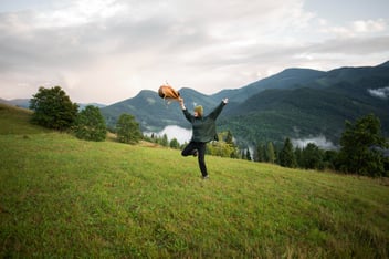 A woman running free on a green field 